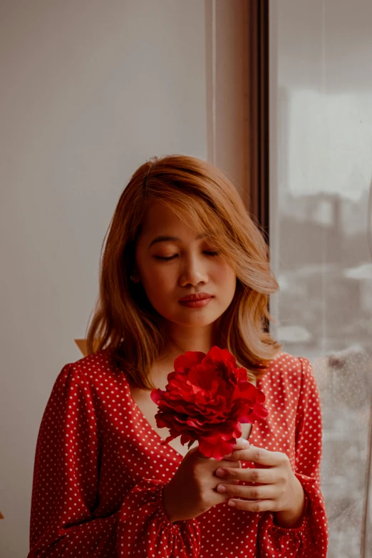 the young woman is holding a bouquet of flowers