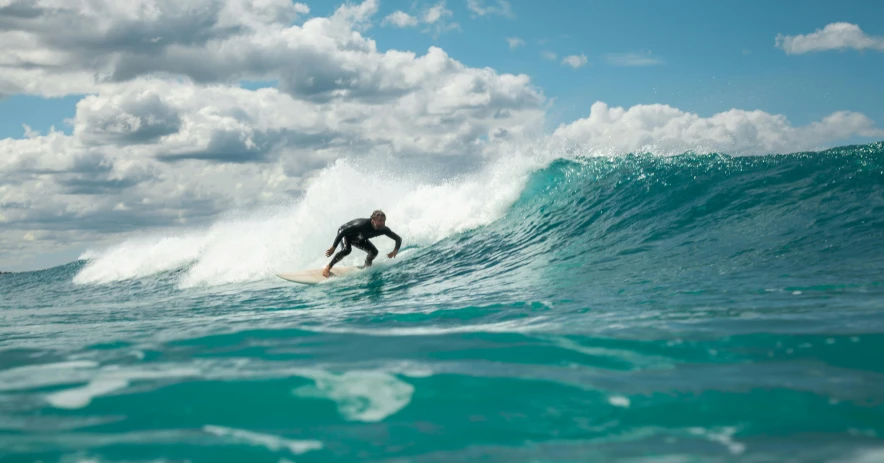 a man riding a wave on top of a surfboard