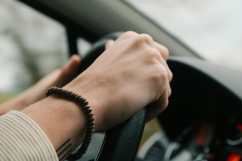 a person holding on to a steering wheel