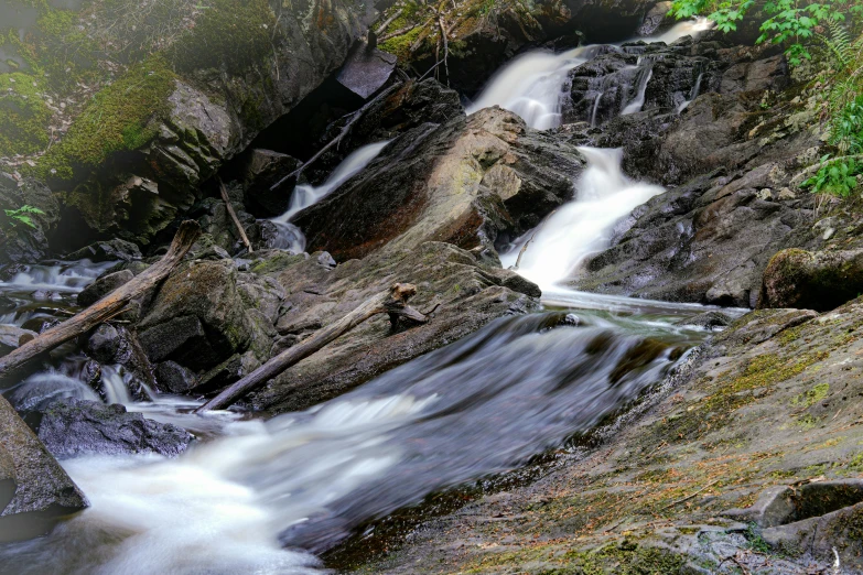 a waterfall falls down some rocks into water