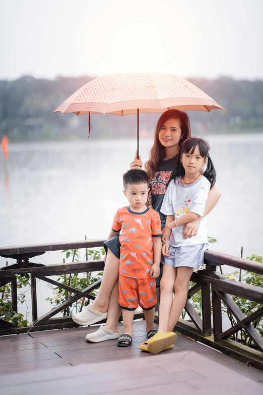 a family of three standing under an umbrella