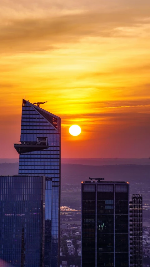 the sun is setting over two buildings