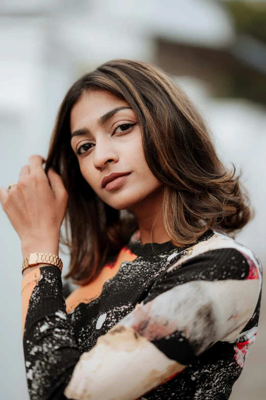 a woman wearing a floral blouse is posing for the camera