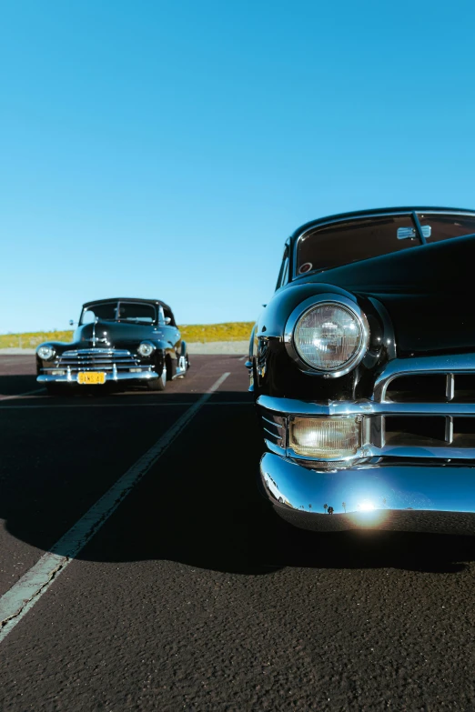 two old fashioned cars parked in a lot