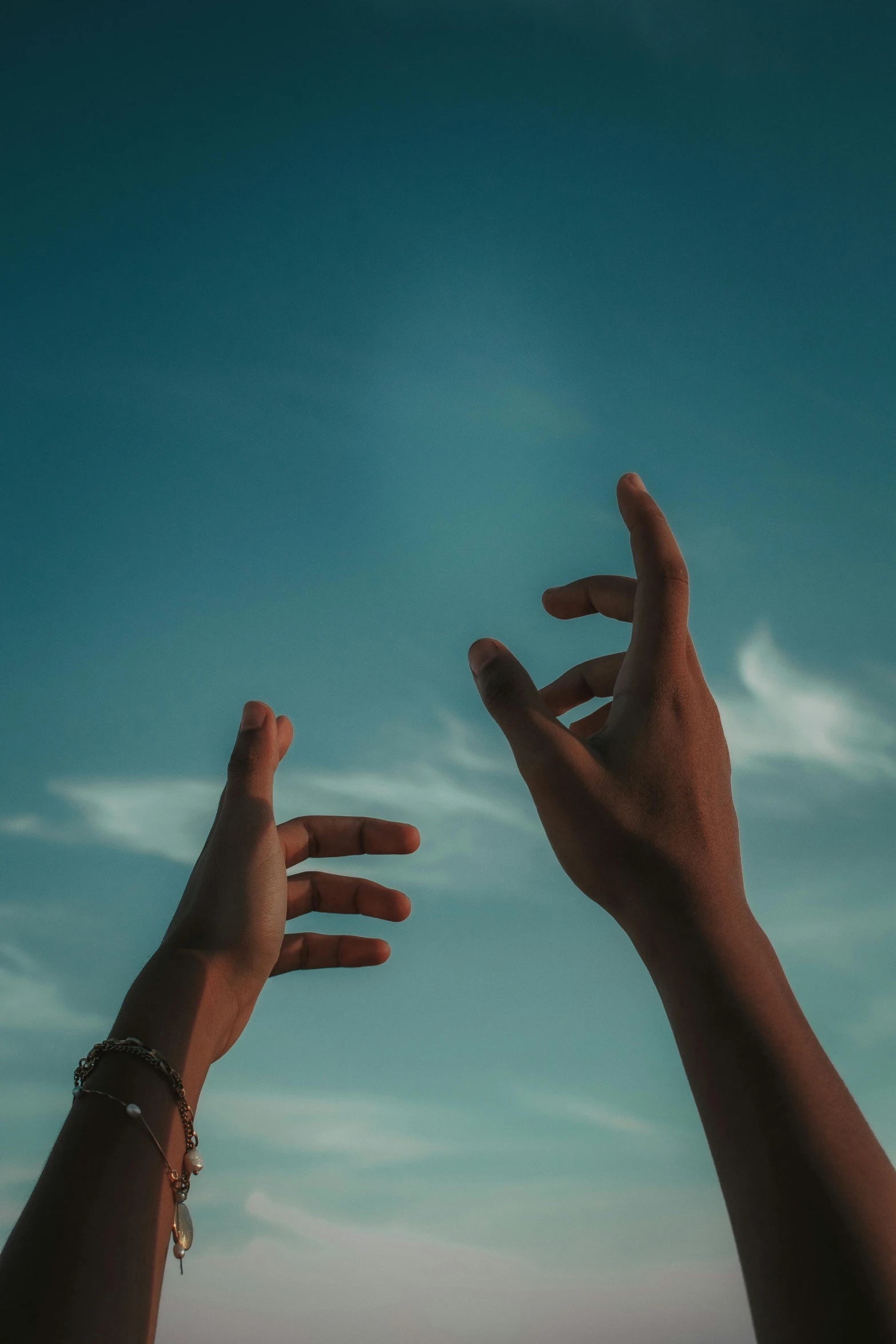 two hands reaching up into the sky to reach soing