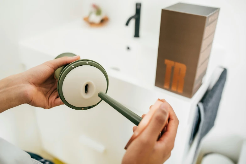 a person holding a toilet brush near a box