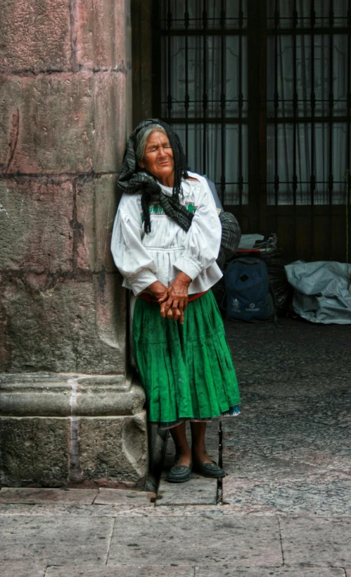 woman wearing traditional mexican clothing in front of a wall