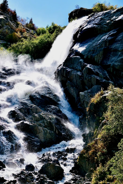 a waterfall gushes water from it into the river