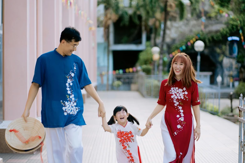 an asian family walks together down a sidewalk