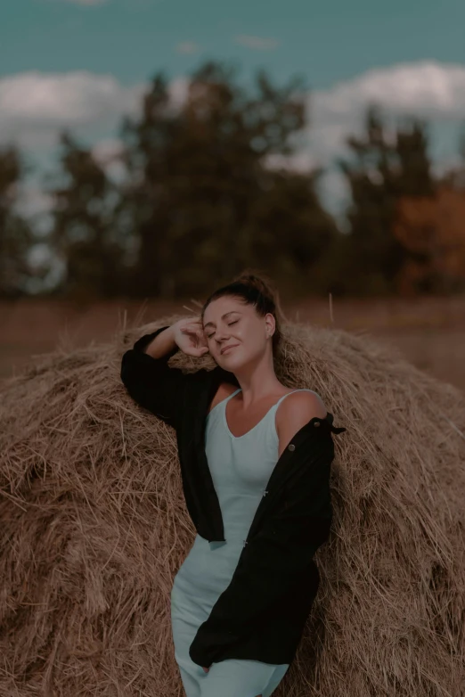 a girl laying down on a pile of hay