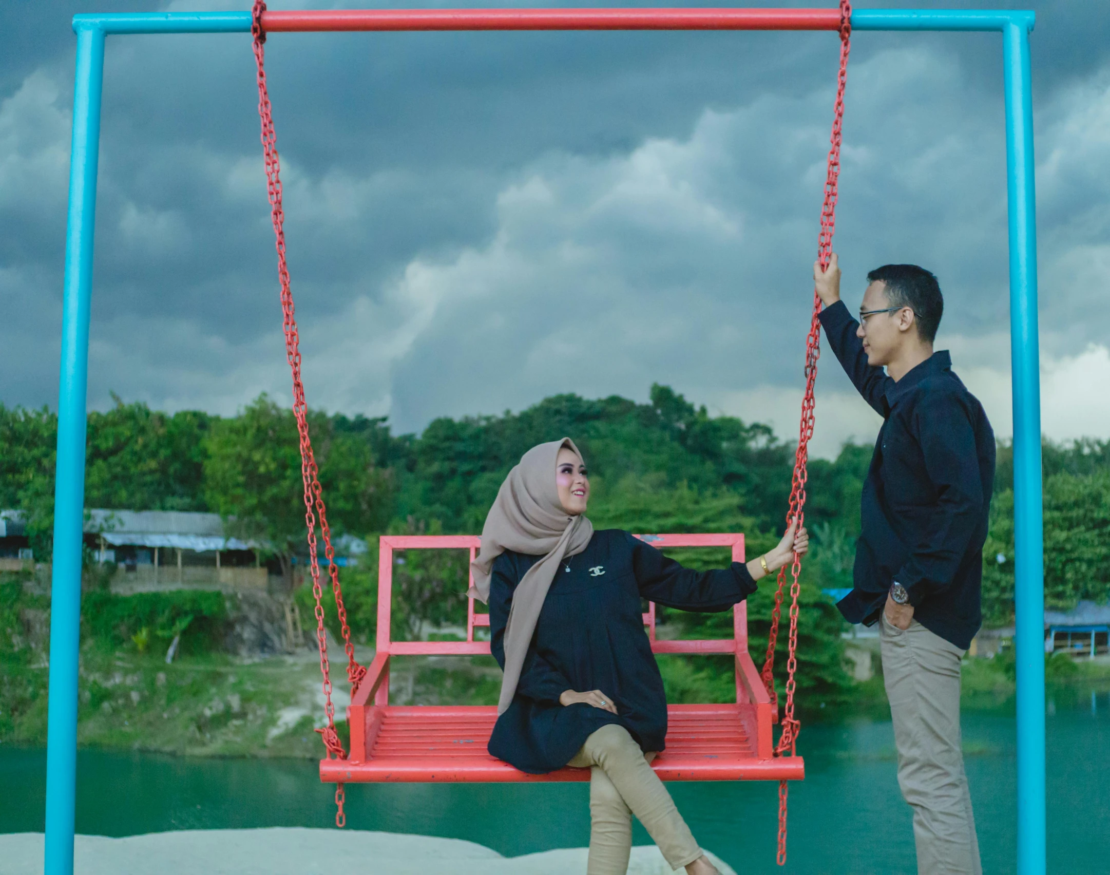 two people stand in front of a swing