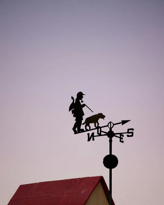 a weather vane, with the image of a dog on top