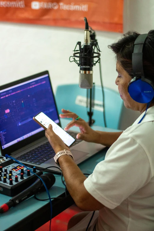 man sitting in front of a laptop and radio microphone