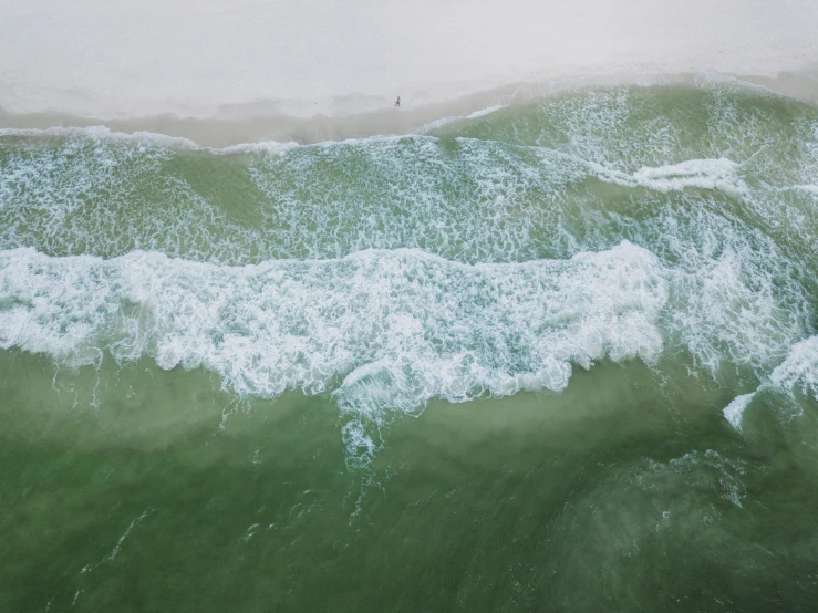 green, green ocean water and a surfer on white waves