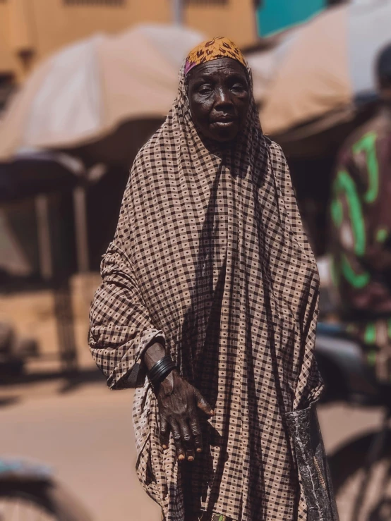 an old black man in traditional garb is holding a stick