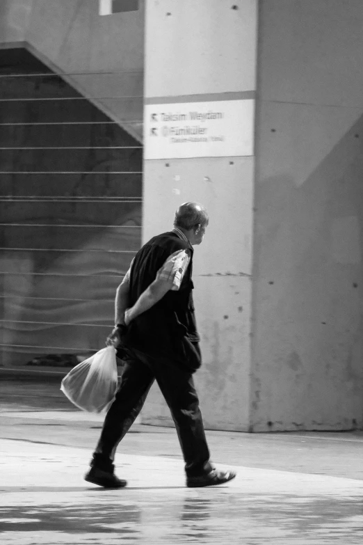 the man walks with a grocery bag across the street