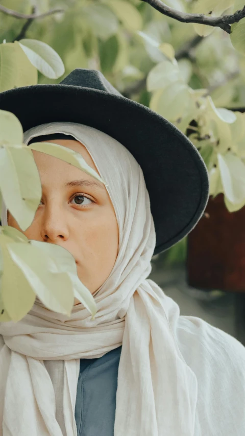 a young woman wearing a hat with leaves around it