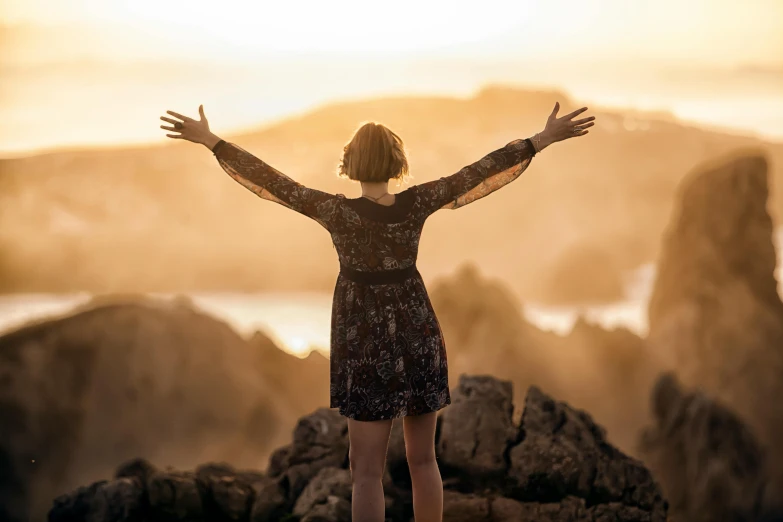 a girl that is standing with her arms outstretched and eyes closed