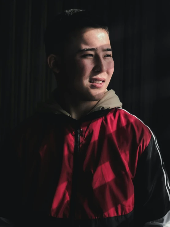 a man in a red and black coat smiles