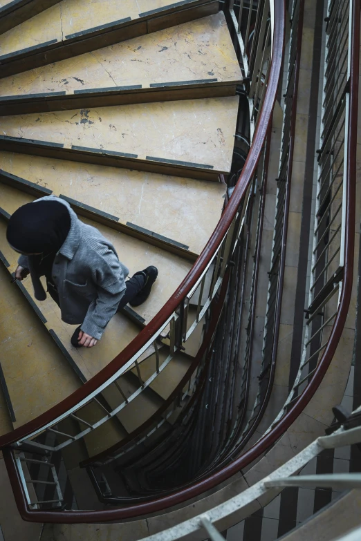 the person in black is sitting on a stair case