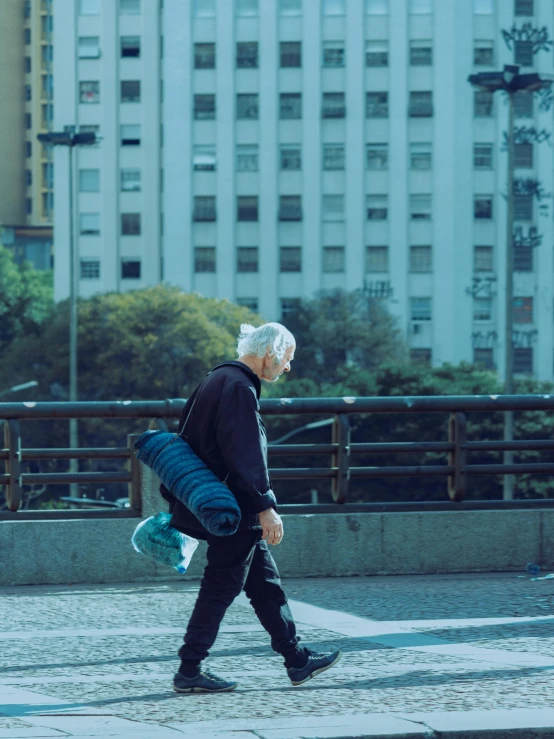 older man walking in the street with a skateboard