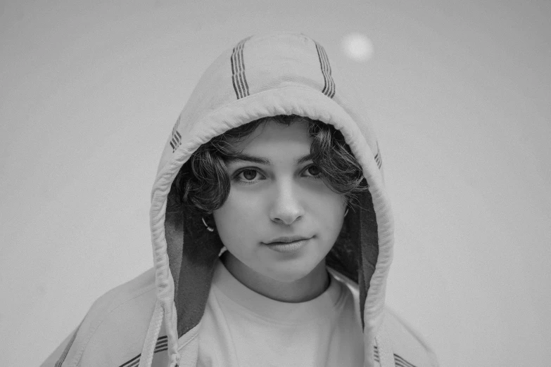 the image is black and white of a person wearing a hoodie