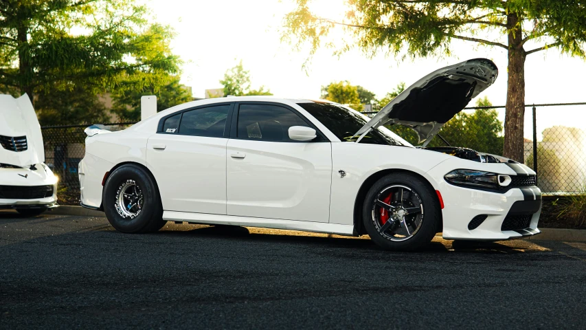 a white car with its trunk open on the street