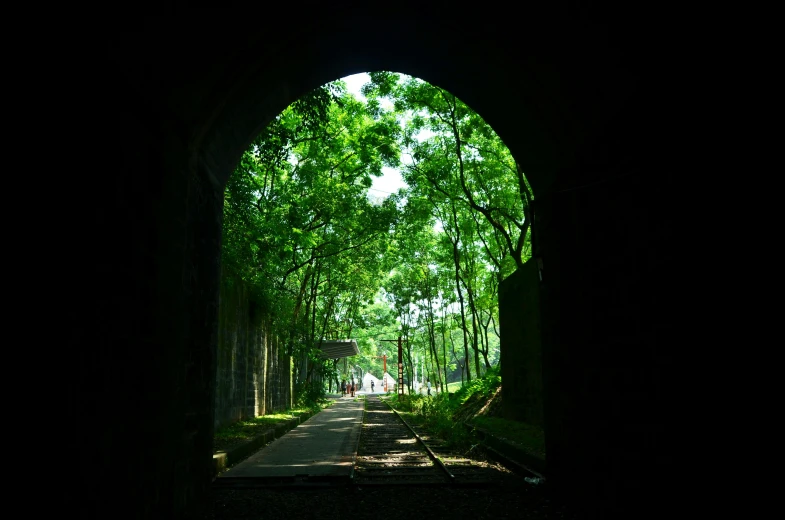 an open archway leading into the woods and green trees