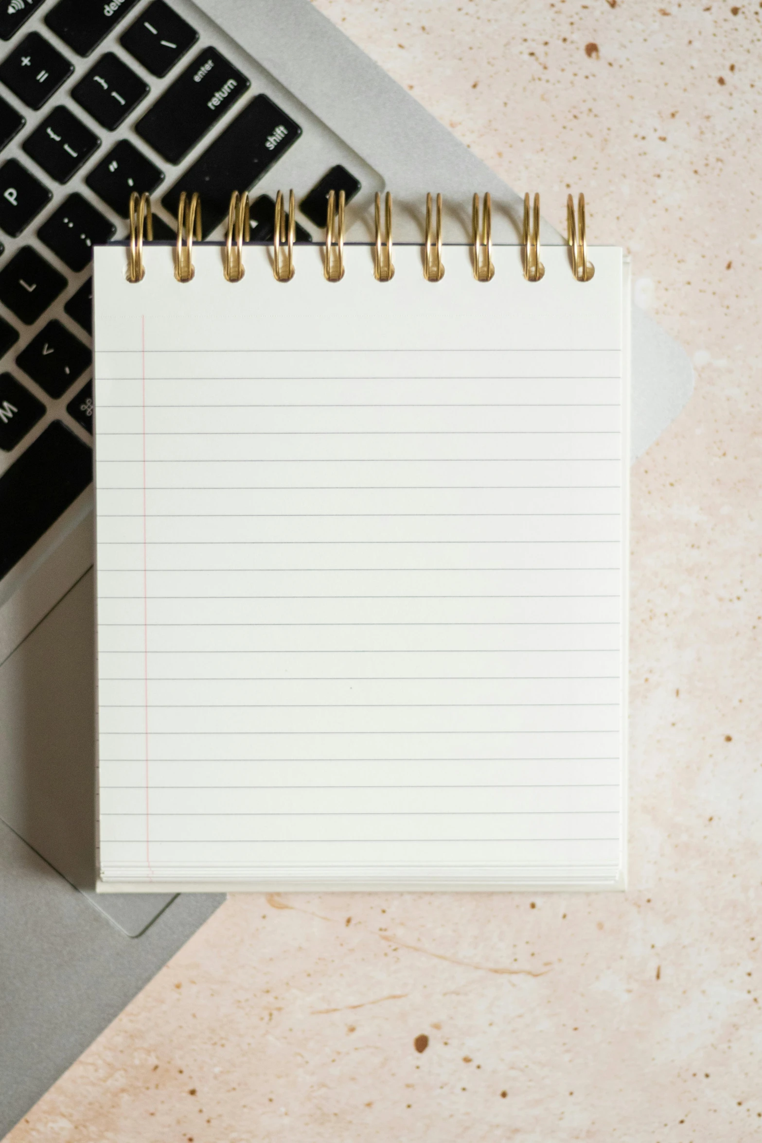 a notebook and a laptop next to it on a desk