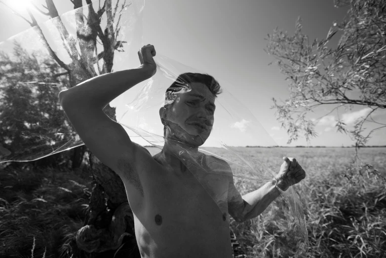 a shirtless man with a sheer veil over his head