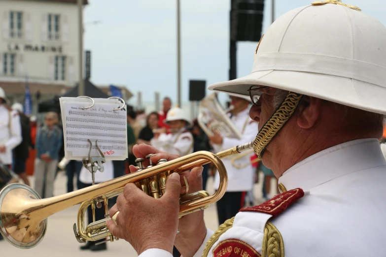 an old man playing a trumpet with music played on the side