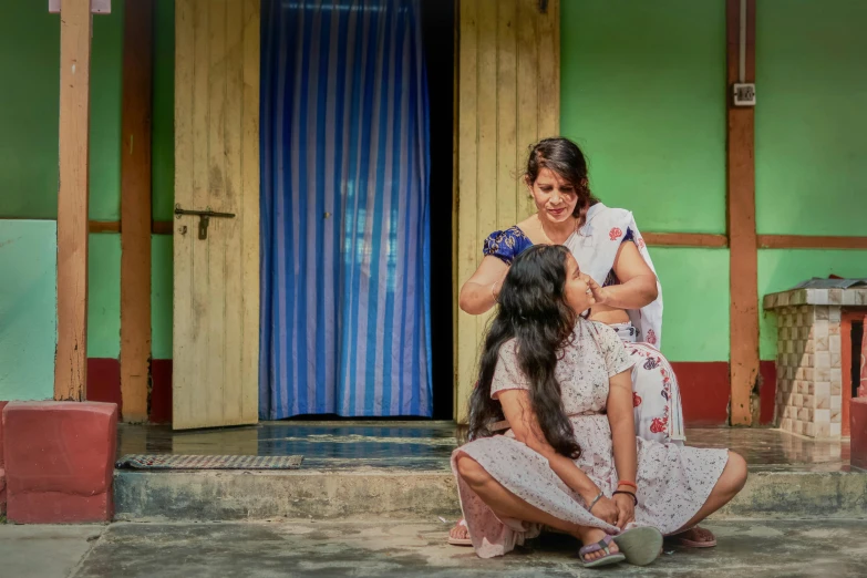 a woman is helping a young child get ready for school