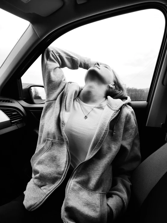 a woman in a car taking a nap