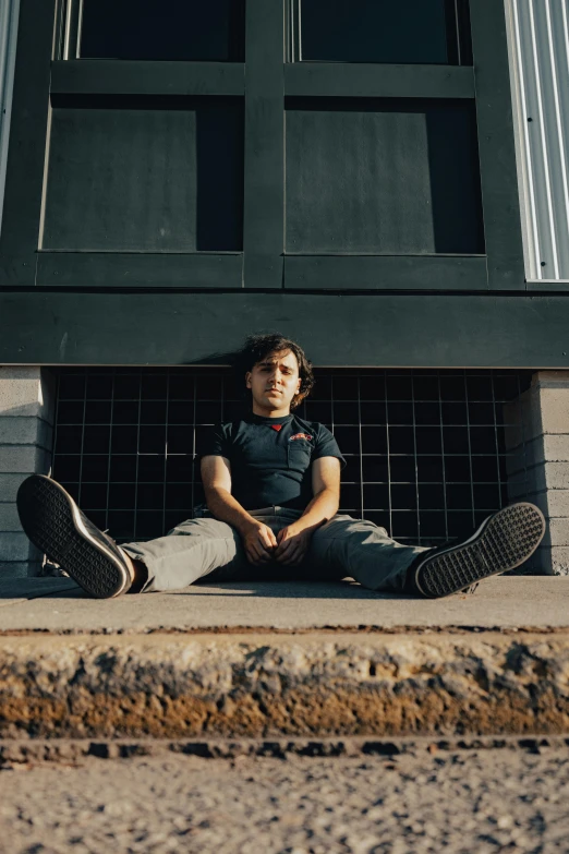 a boy with long hair sitting on the ground