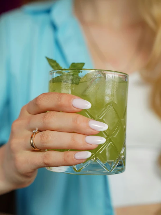 a woman is holding up a drink glass