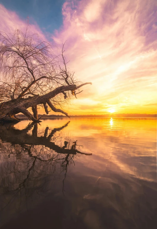 the sun is rising over a large lake