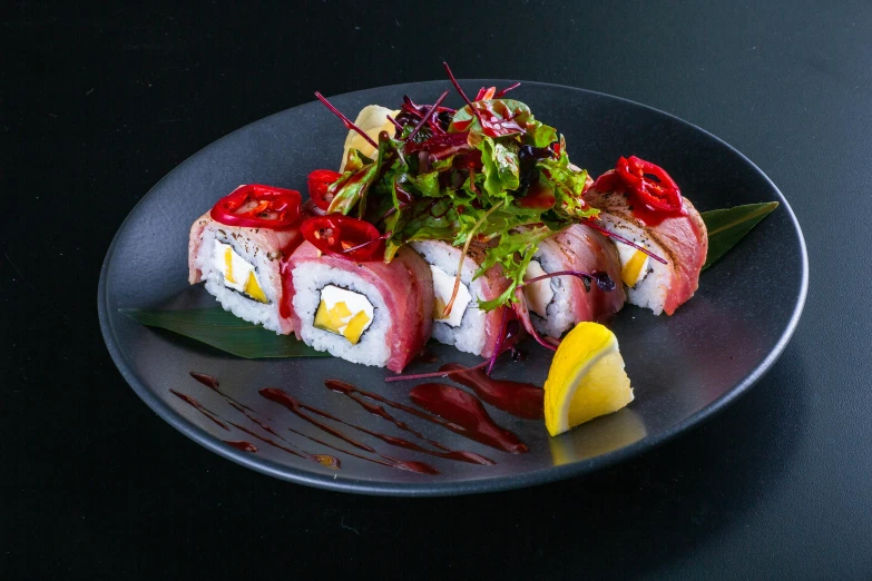 a plate that has a sushi and a lemon on it