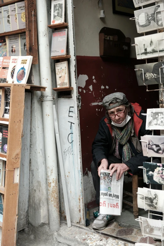 a man standing in a doorway with many framed pos