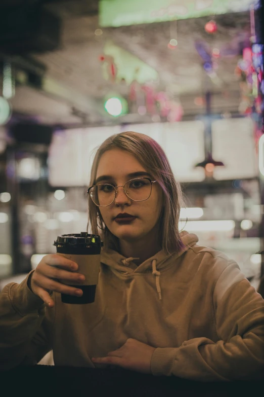 a woman with glasses holding a coffee cup