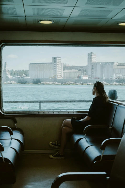 the woman is riding on a train with her back to the window