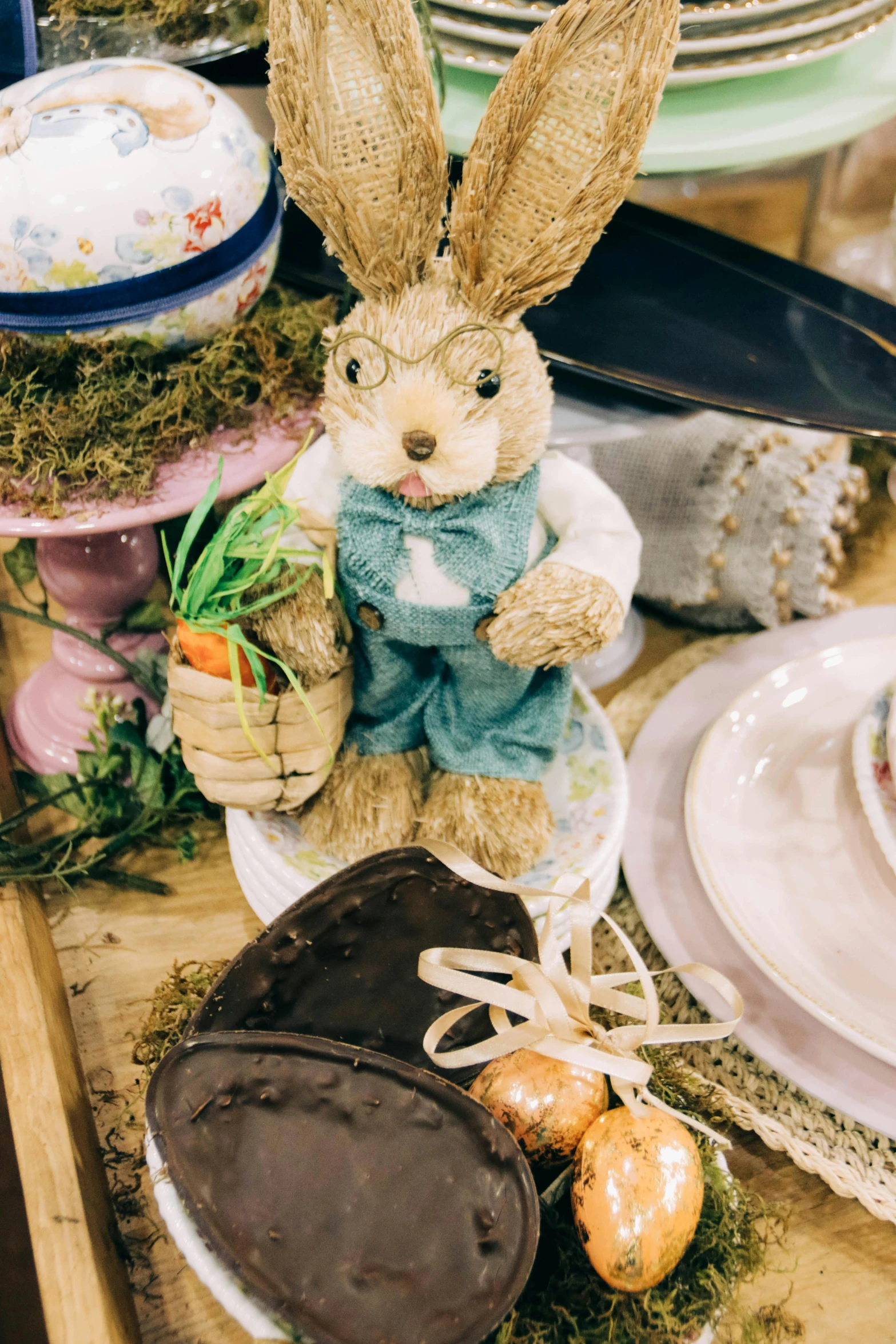 an adorable bunny doll sitting on a table with easter decorations