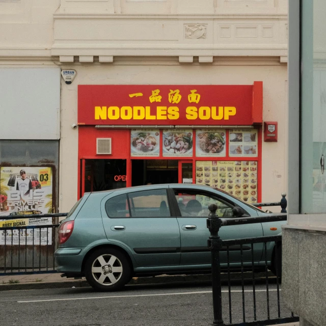 a car parked in front of a noodles soup shop