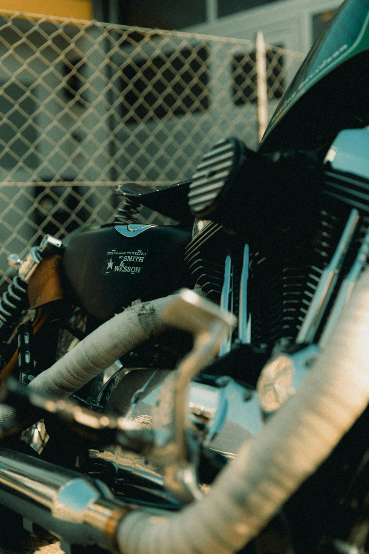 a picture of a black motorcycle parked in a fenced area