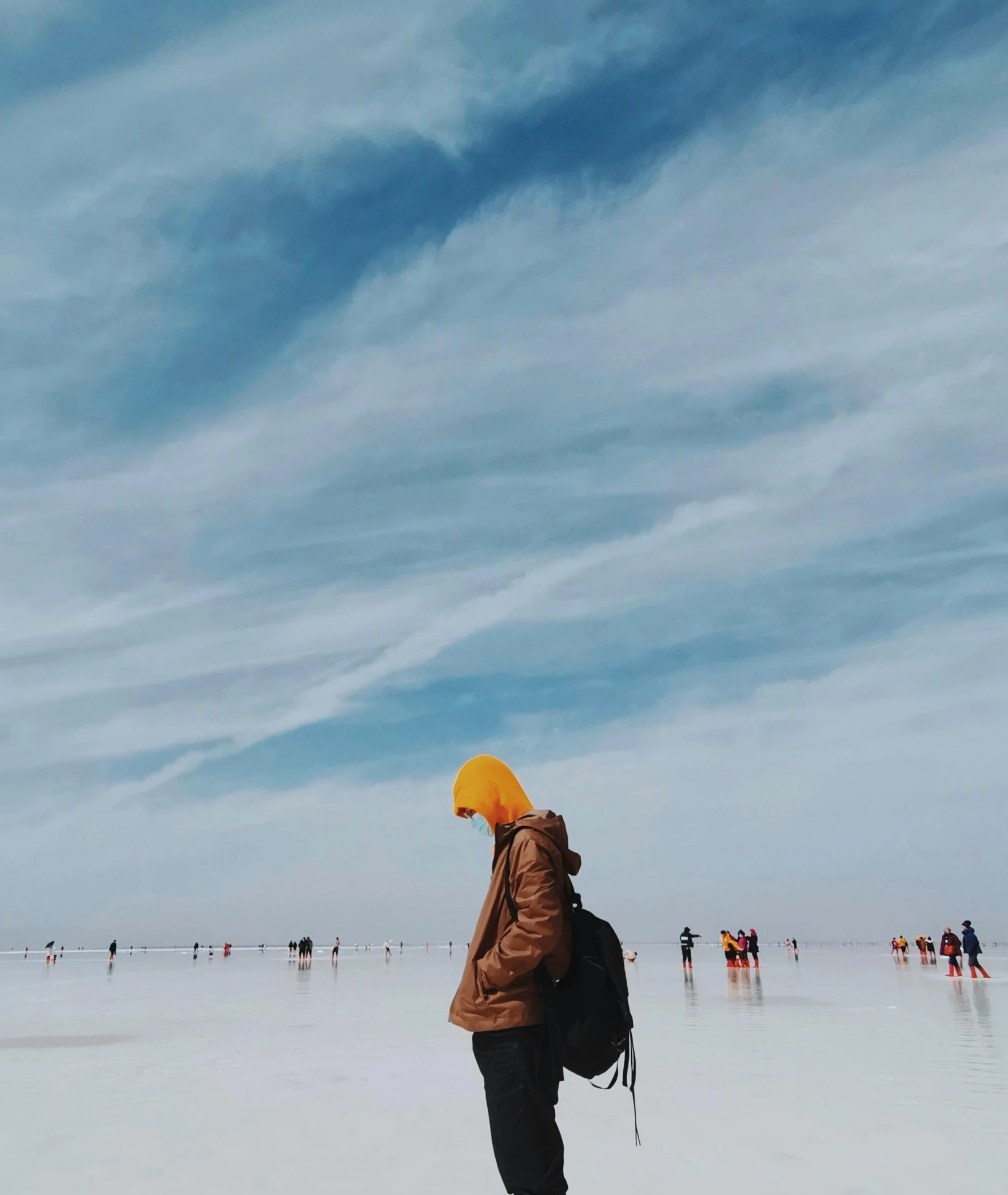 a woman standing on top of a beach under a blue sky