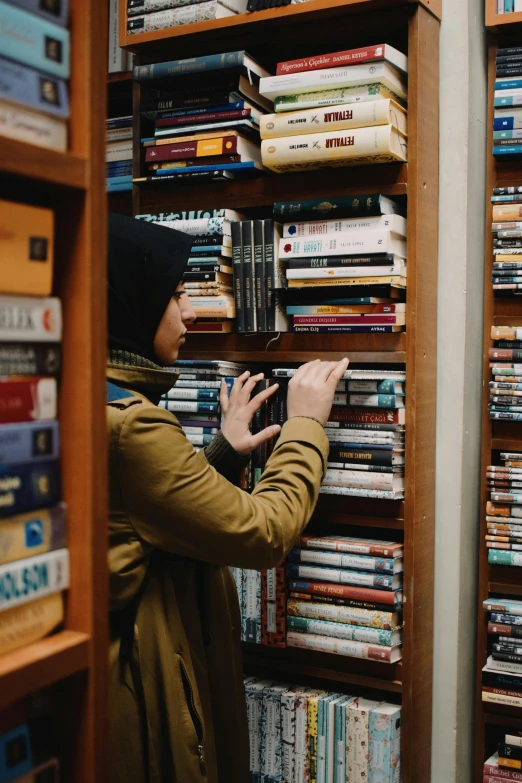 a woman looking through stacks of books