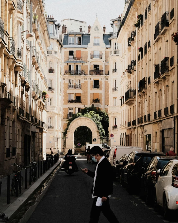 man walking through an alley between two buildings