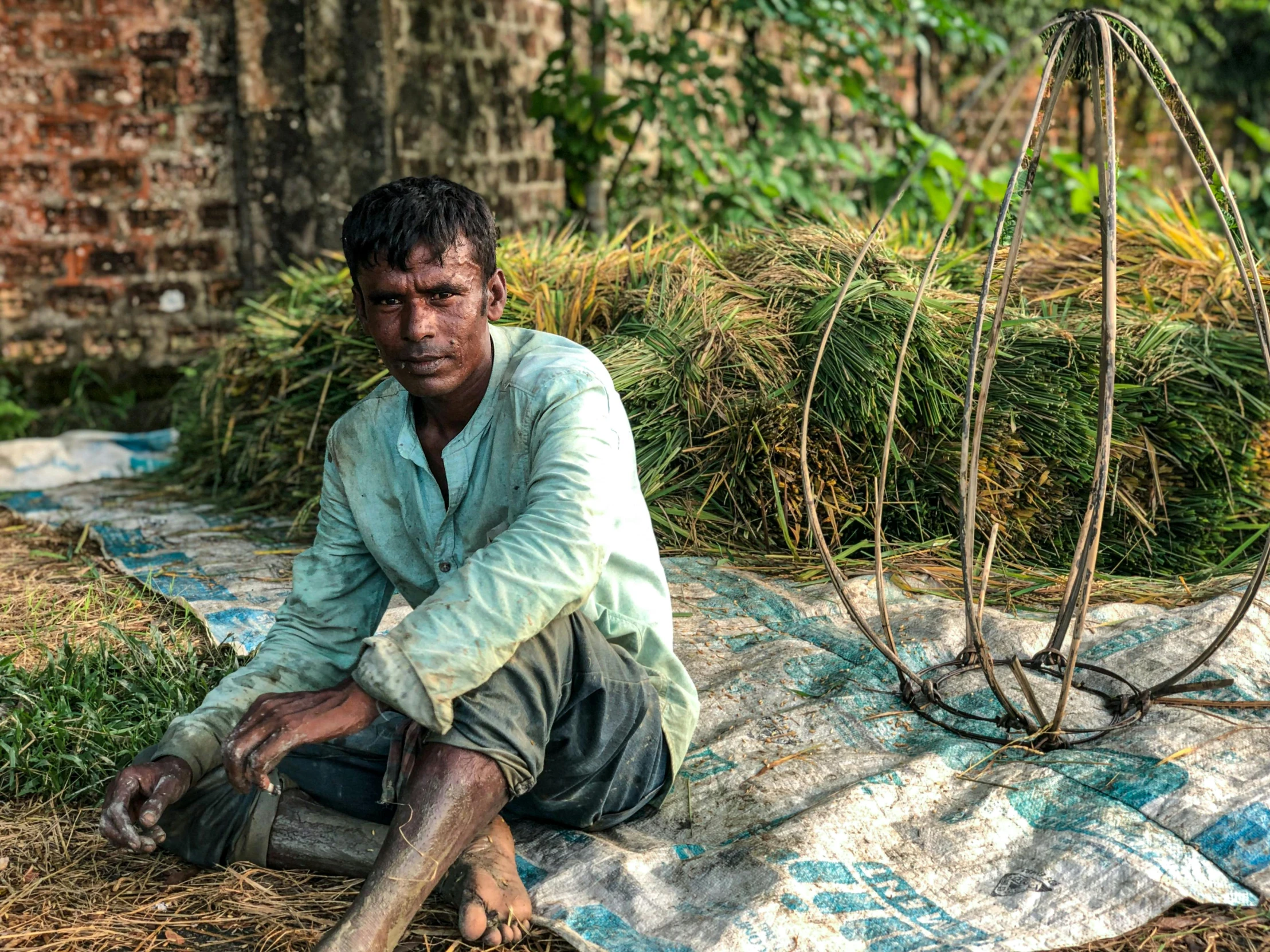 a man sits on a blanket next to two large circular metal sculptures