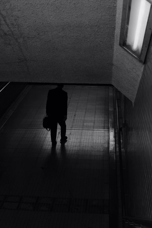 a person stands on a tile platform in a dark tunnel