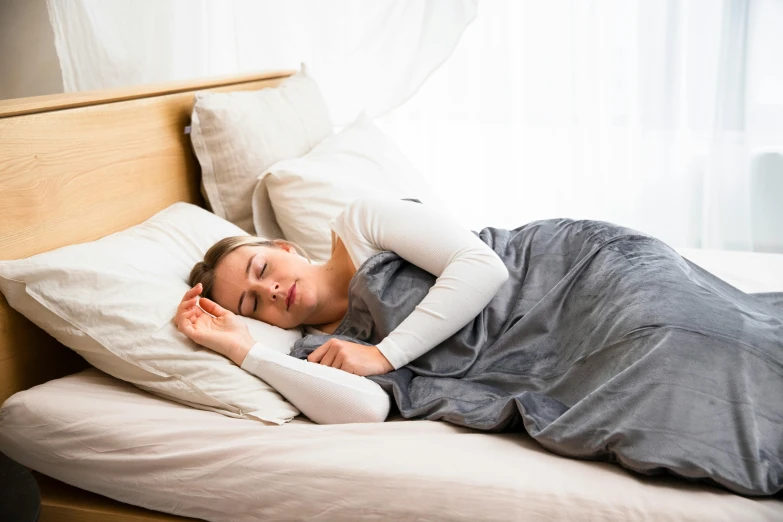 a woman sleeps in her bed while holding a pillow