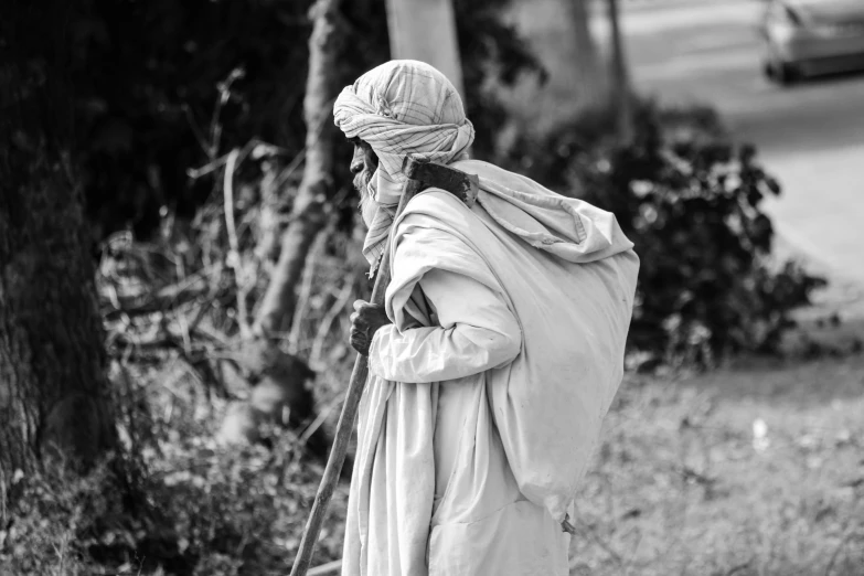 a man is walking down the sidewalk wearing a turban